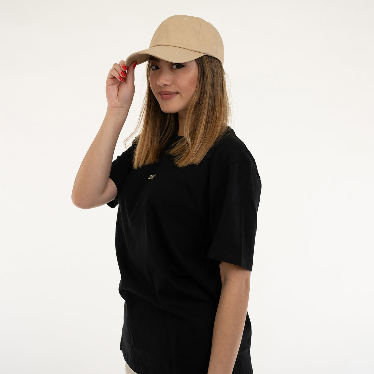 Frau mit mittellangen braunen Haaren trägt die sandfarbene Damen-Cap 'Jen' von Johnny Urban und ein schwarzes T-Shirt