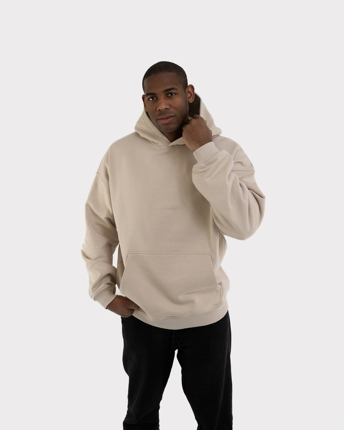 Mann trägt oversized Hoodie 'Cody' in hellem Grau mit Kängurutasche und Kapuze