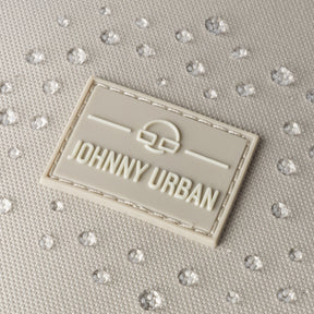 Nahaufnahme des Johnny Urban Logos auf Stoff mit Wasserperlen, zeigt wasserfesten Rucksack 'Nico'