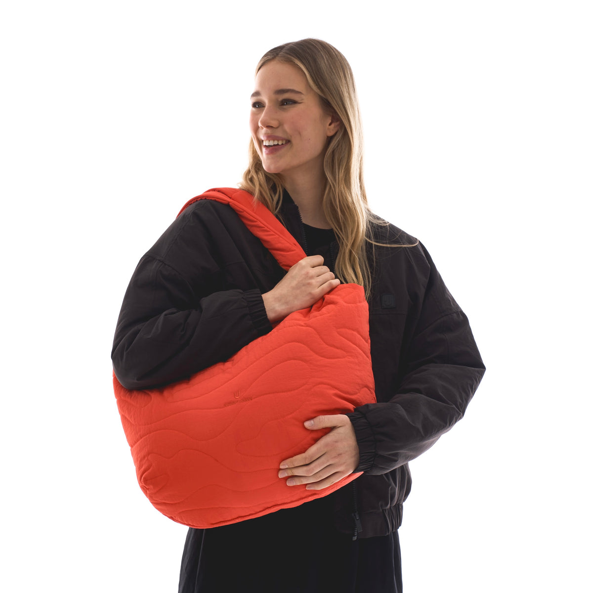 Unser weibliches Model präsentiert hier die Shopper-Bag "Cleo" in einzigartigem coral-rot. 