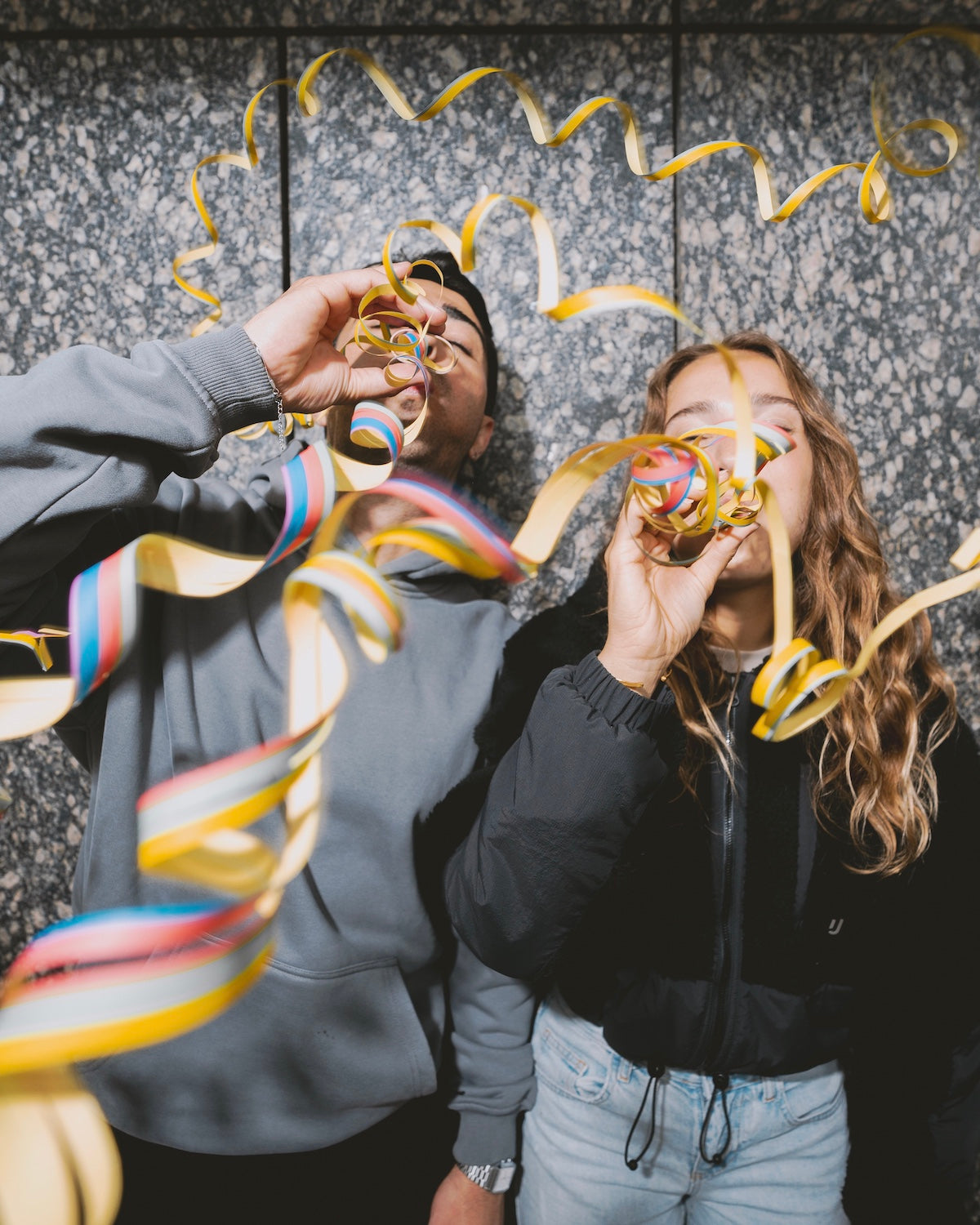 Stets mit guter Laune feiern ein Mann und eine Frau hier gerade eine Party und pusten Luftschlangen. 