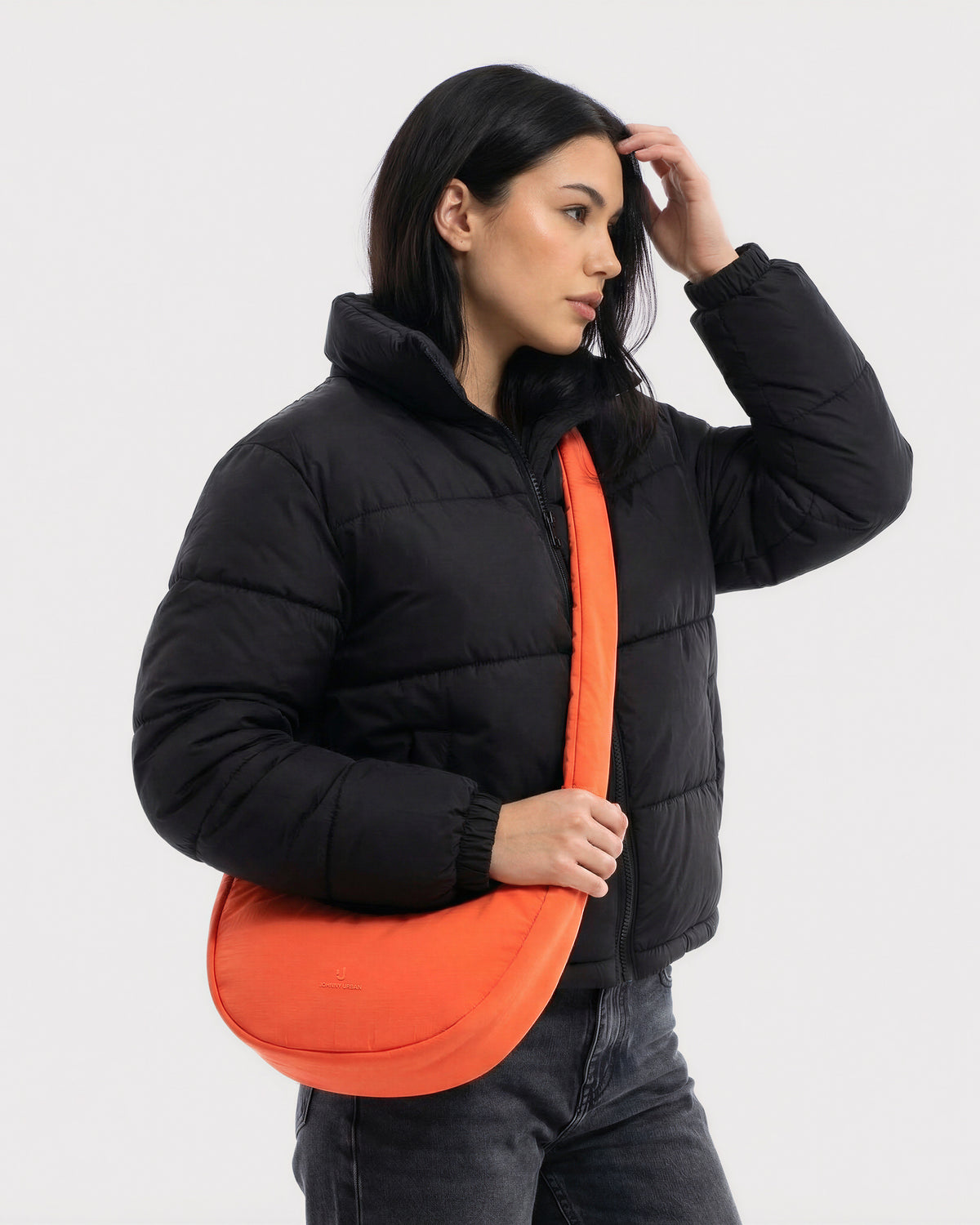 Unser weibliches Model zeigt sich hier mit der Johnny Urban Half-Moon-Bag "Lou Medium" in coral-rot. 