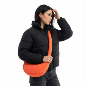 Unser weibliches Model zeigt sich hier mit der Johnny Urban Half-Moon-Bag "Lou Medium" in coral-rot. 