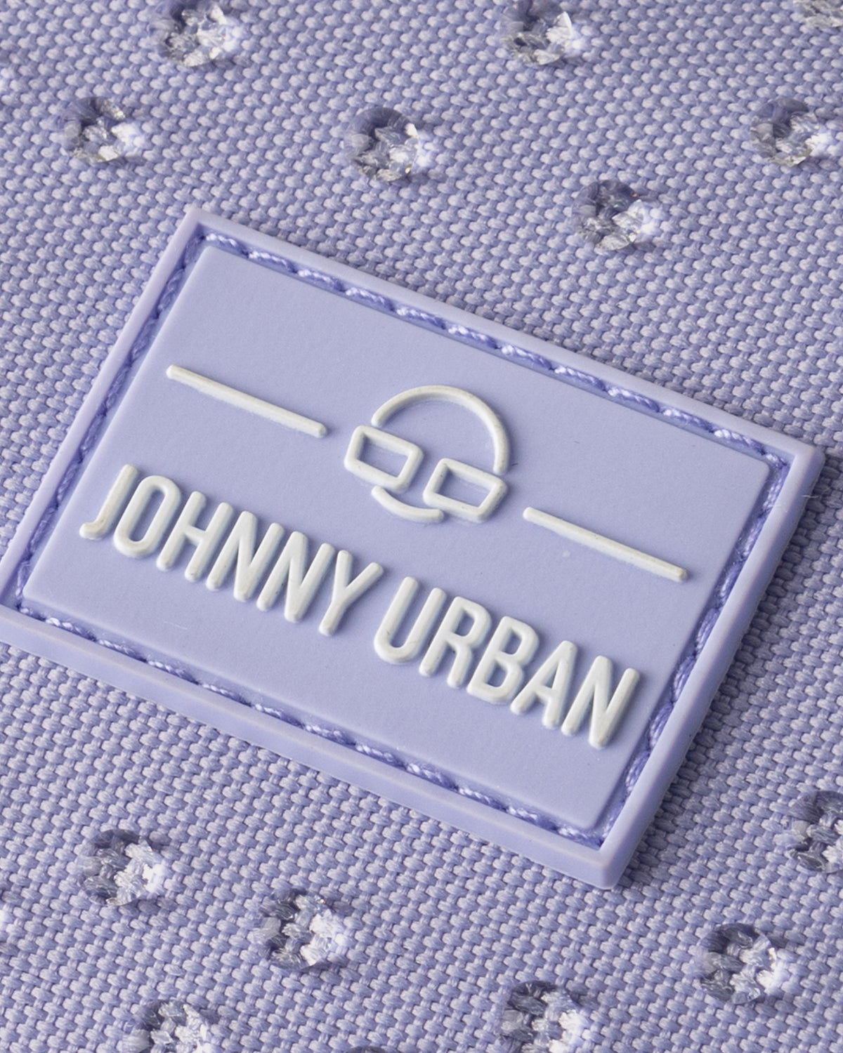 Nahaufnahme des Johnny Urban Logos auf wasserabweisendem lila Stoff der Half Moon Bag 'Ally Small'
