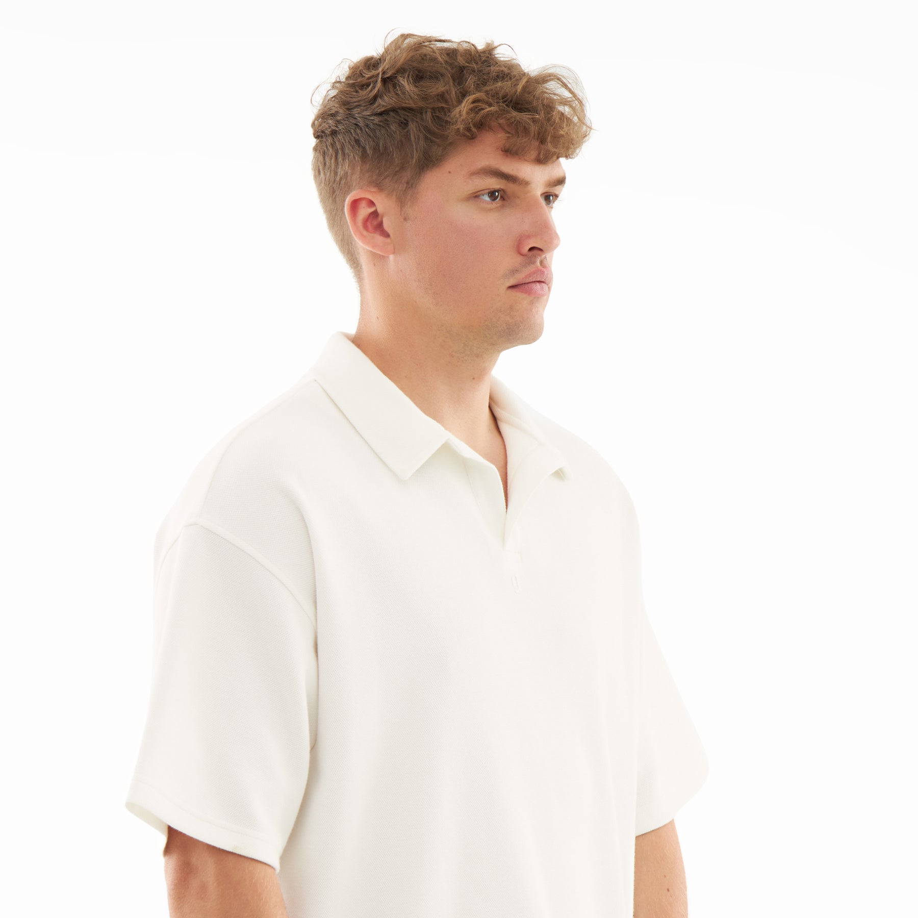 Mann trägt cremefarbenes Herren-Poloshirt mit kurzem Arm und offenem Kragen