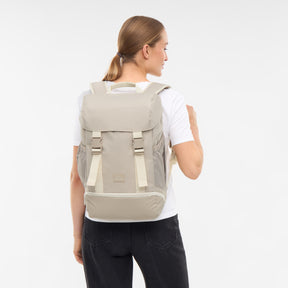 Frau von hinten mit sandfarbenem Rucksack 'Nico' von Johnny Urban, weißes T-Shirt, schwarze Hose