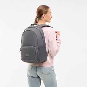 Frau trägt dunkelgrauen Rucksack 'Mo' von Johnny Urban, rosa Pullover, blaue Jeans