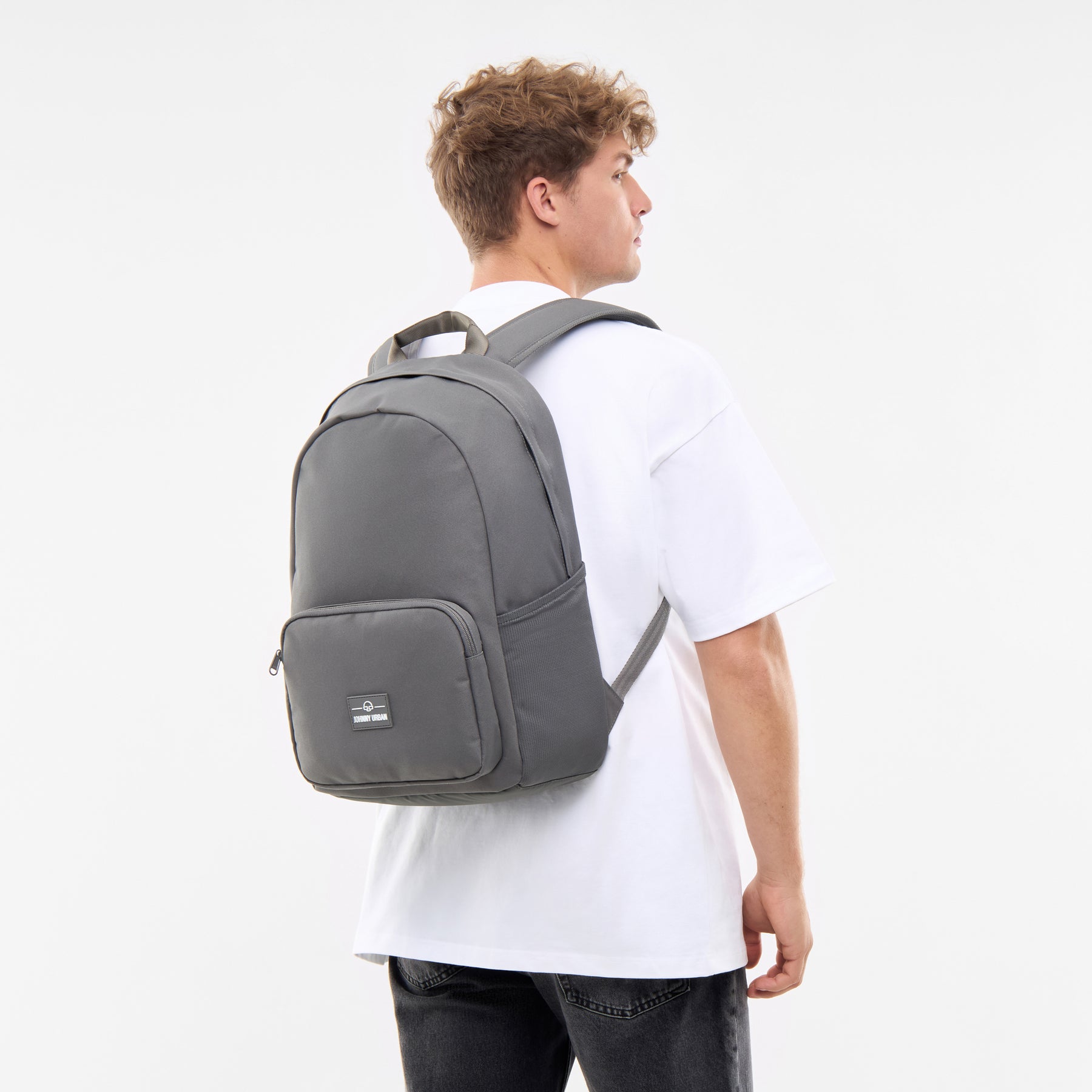 Mann trägt dunkelgrauen Rucksack 'Mo' von Johnny Urban, weißes T-Shirt, Rückenansicht