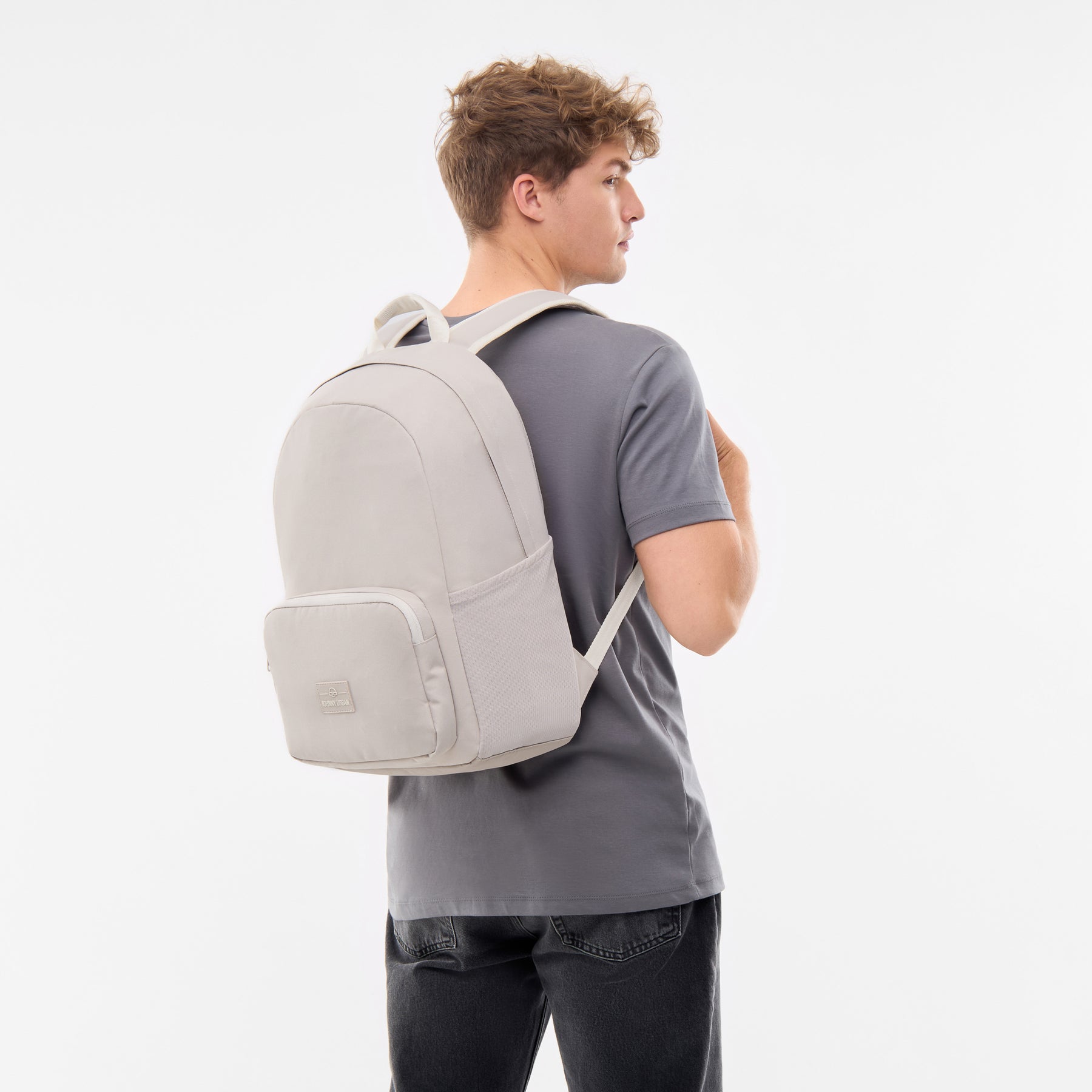 Mann trägt sandfarbenen Rucksack 'Mo' von Johnny Urban mit seitlichen Taschen und Frontfach