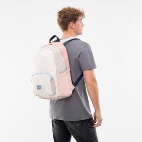 Junger Mann trägt Rucksack 'Mo' in Sand- und Rosatönen auf dem Rücken