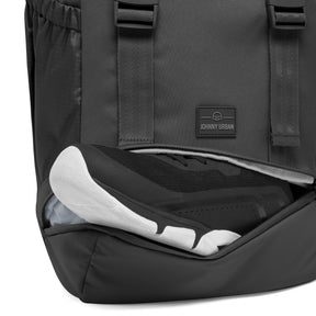 Schwarzer Johnny Urban Rucksack 'Nico' mit offenem Schuhfach, das einen schwarzen Sportschuh mit weißer Sohle enthält