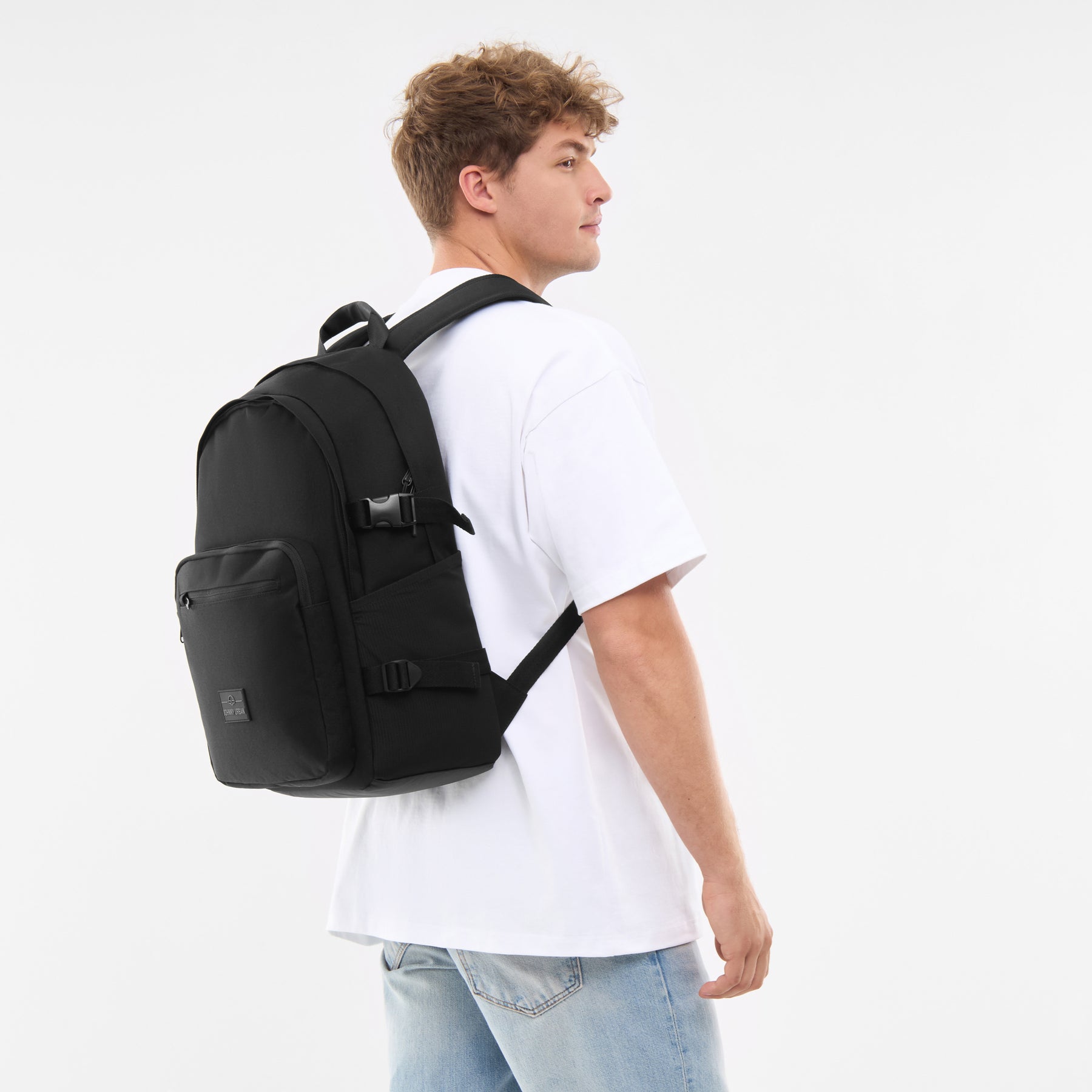 Mann trägt schwarzen Rucksack 'Lian' mit Fronttasche und Schnallen, weiße T-Shirt, blaue Jeans