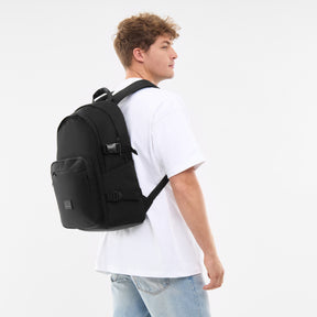 Mann trägt schwarzen Rucksack 'Lian' mit Fronttasche und Schnallen, weiße T-Shirt, blaue Jeans