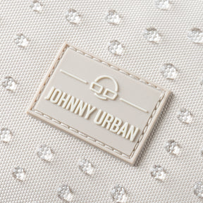 Nahaufnahme des Johnny Urban Logos auf sandfarbenem, wasserdichtem Rucksackstoff mit gepunkteter Struktur