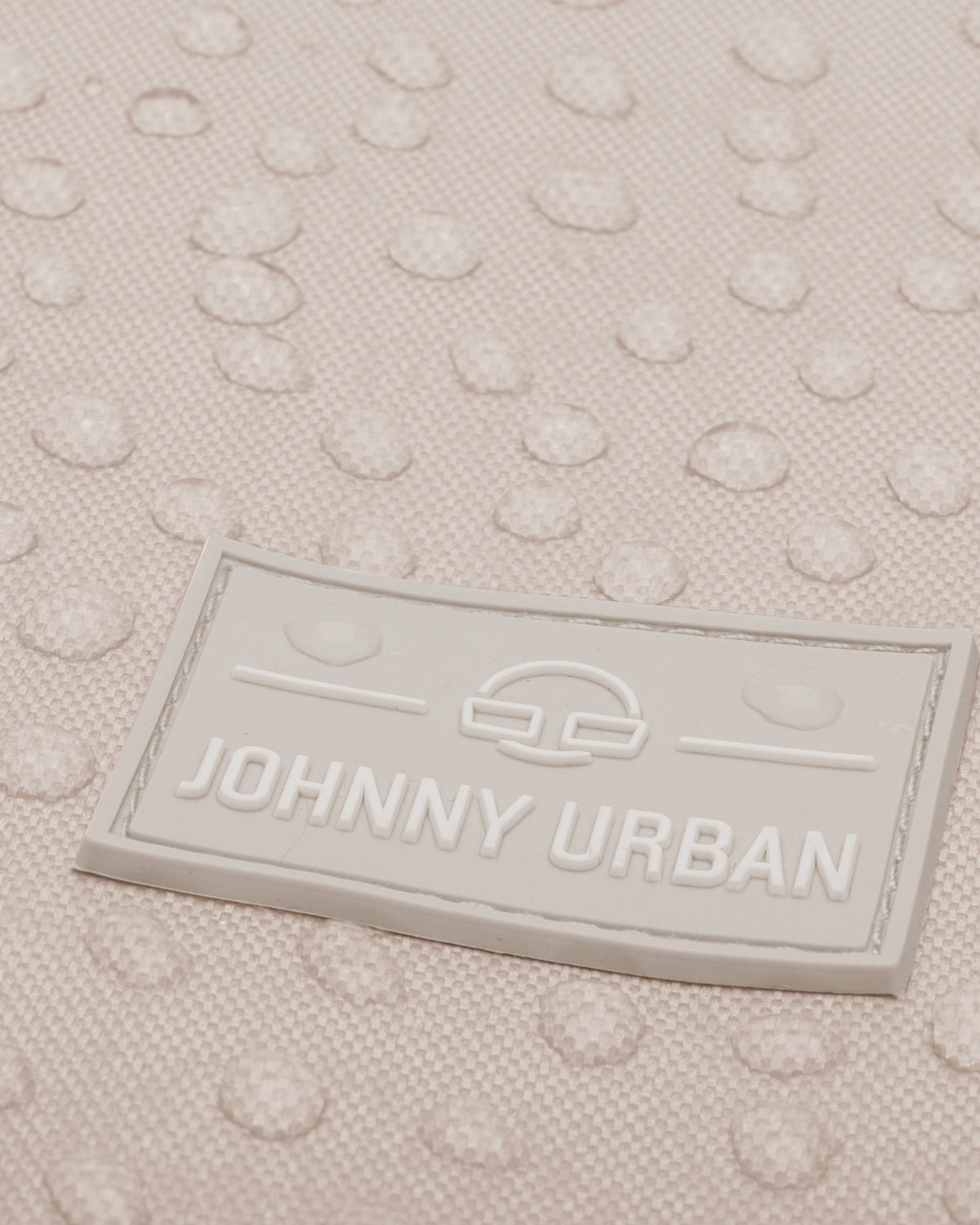 Nahaufnahme des wasserabweisenden beigen Turnbeutels 'Blake' mit geprägtem Johnny Urban Logo