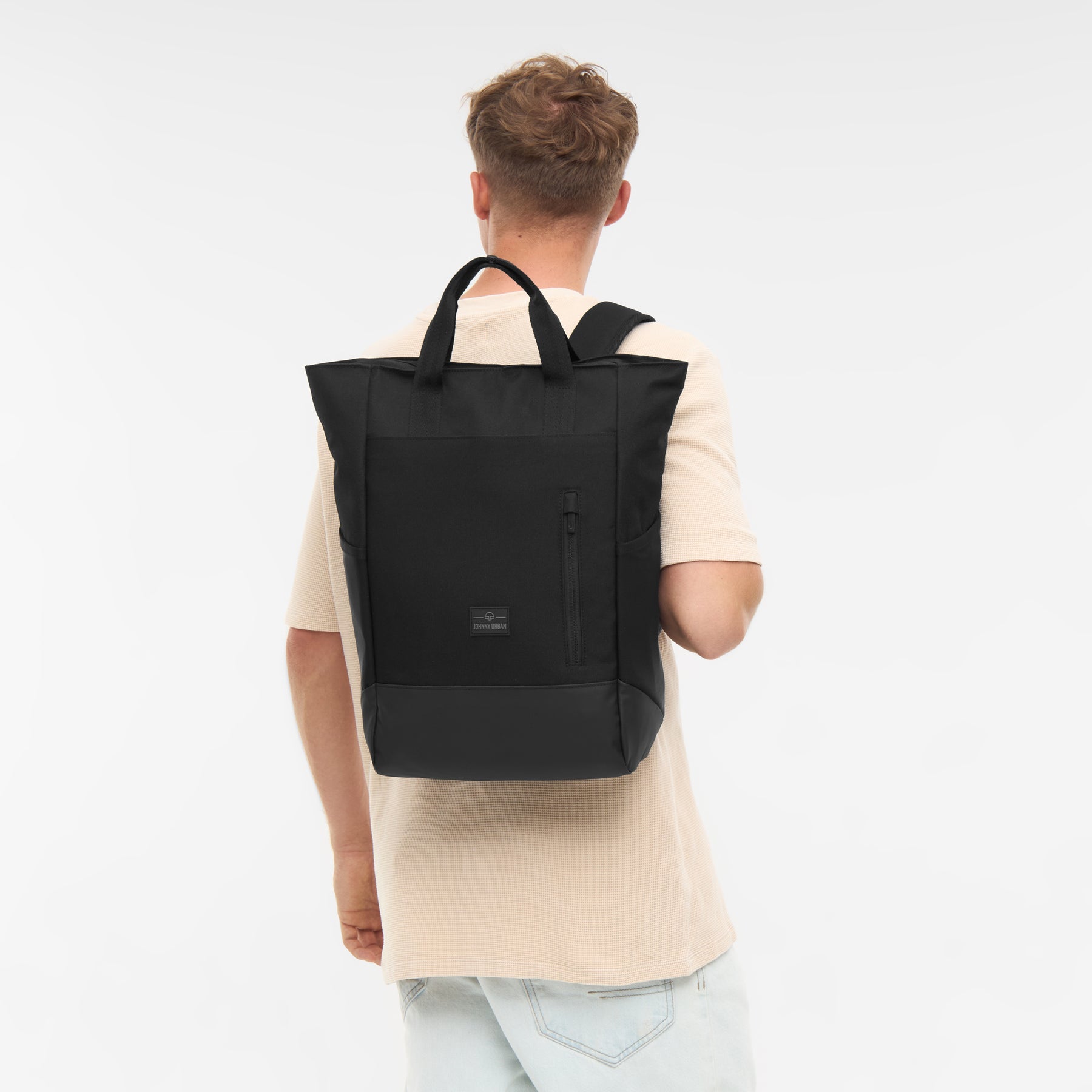 Mann von hinten mit schwarzer Wickeltasche 'Blair' als Rucksack