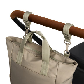 Beige Wickeltasche 'Blair' aus robustem Material, befestigt an Kinderwagen mit zwei Schlaufen