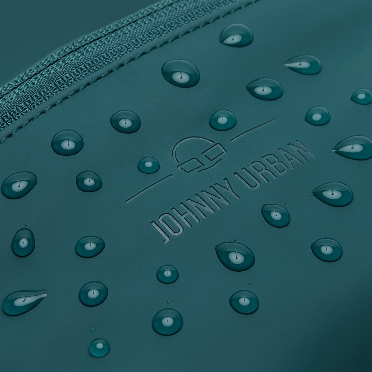 Detailaufnahme der wasserabweisenden petrolgrünen Bauchtasche 'Riley' von Johnny Urban mit Wassertropfen
