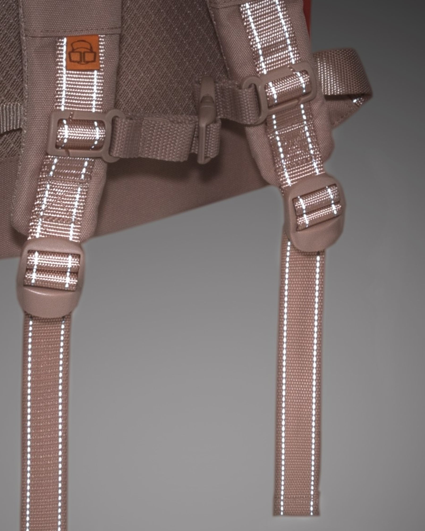 Nahaufnahme der verstellbaren Träger mit reflektierenden Linien und Sicherheitsgurt des Rolltop Kinderrucksacks 'Aaron'