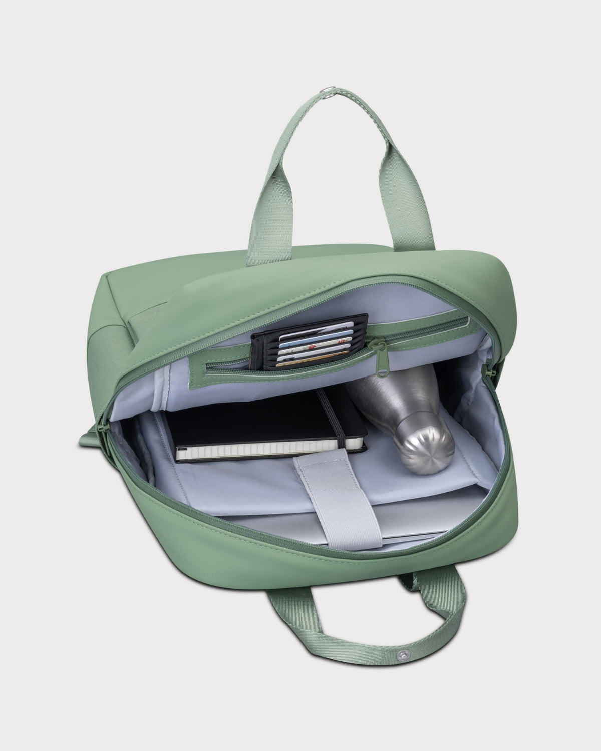 Grüner Tagesrucksack 'Jona Medium' geöffnet mit Notizbuch, Metallflasche und Kartenfach